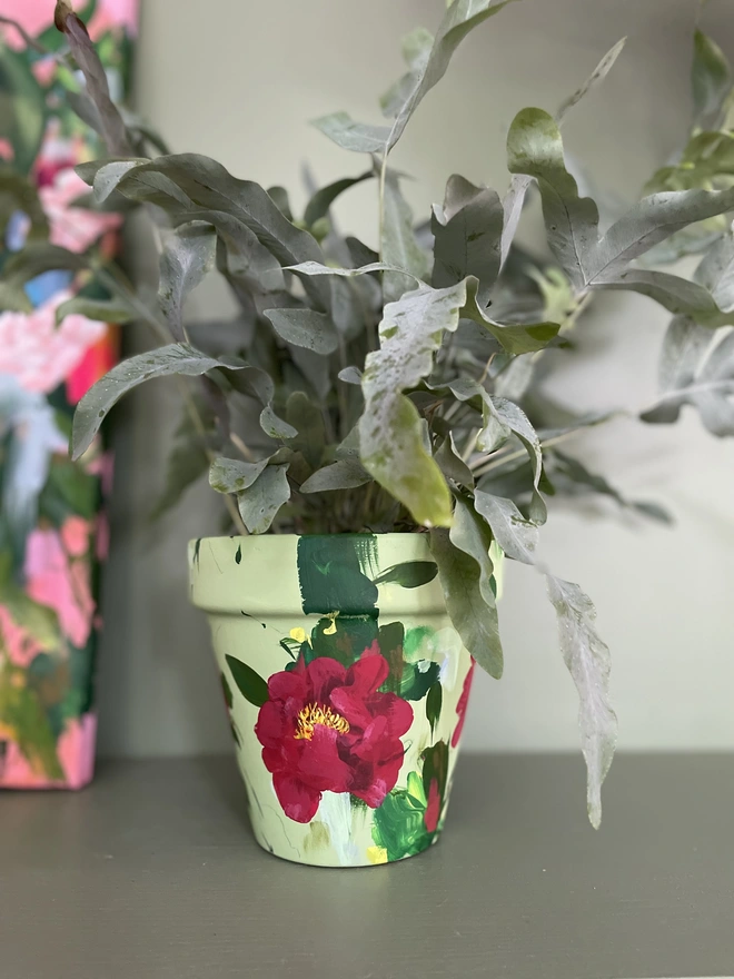 Hand painted pale green plant pot with deep red peonies