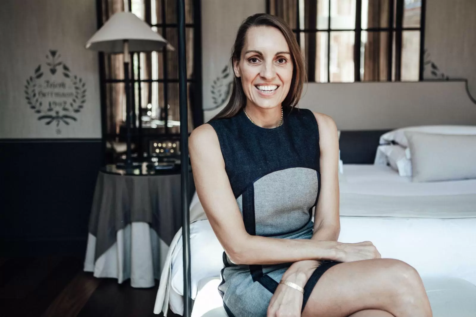 Tamara Lohan MBE, co-founder of Mr and Mrs Smith, smiling at the camera in a blue and grey denim dress. 