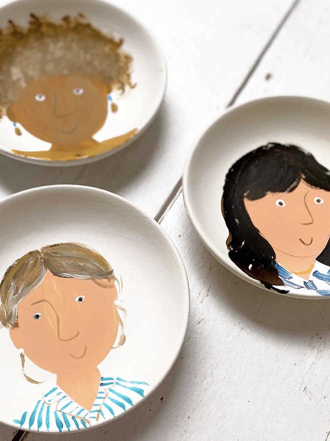 collection of small white plates with stylised painted portraits