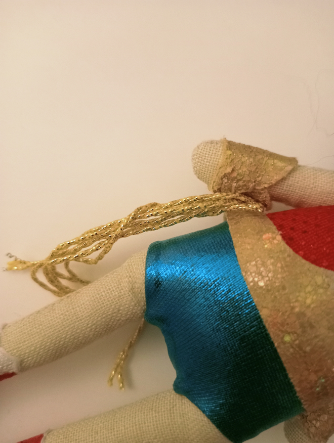 Close up of mini decorative wonder woman doll showing blue shirts golden rope and gold belt