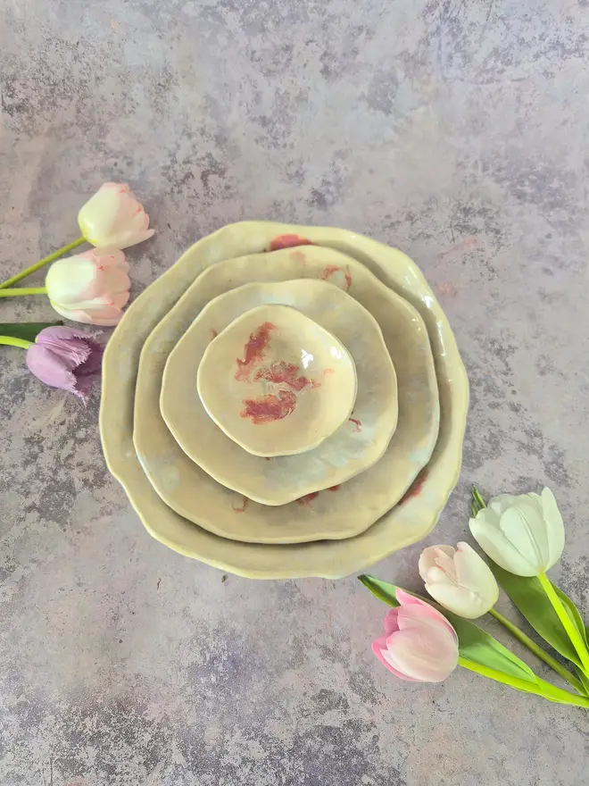 Tableware, serveware, Nesting set of four handcrafted ceramic bowls in an Dream Catcher and Rose glaze with pearlescent white and cream and pink, breakfast bowl, serving bowl, gift, potter, tableware, dinnerware, photographed on a pink background with flowers.
