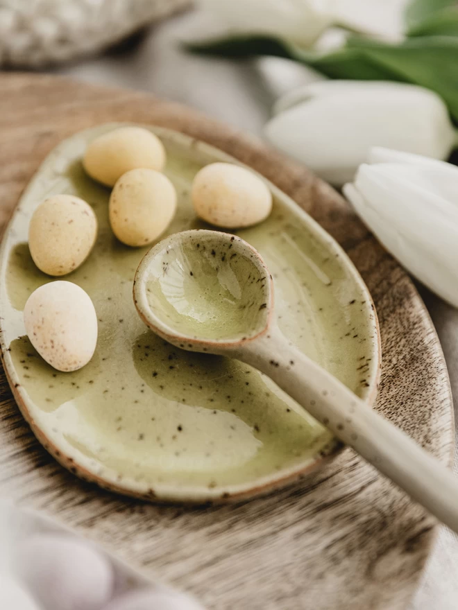 yellow ceramic spoon, laid on a yellow egg shaped plate