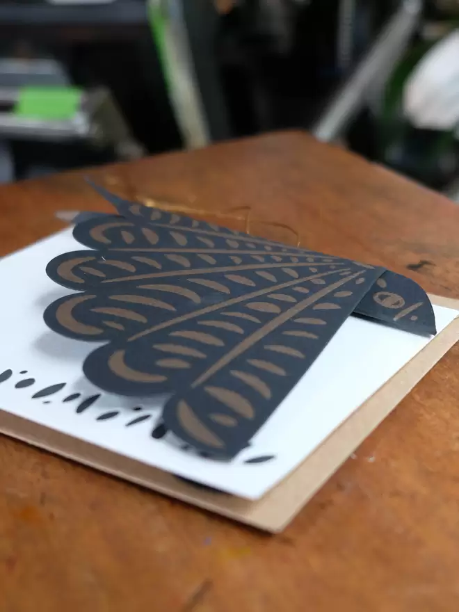 Black and gold letterpress printed bird decoration – folded flat to the size of an A6 card. White notecard and kraft envelope.