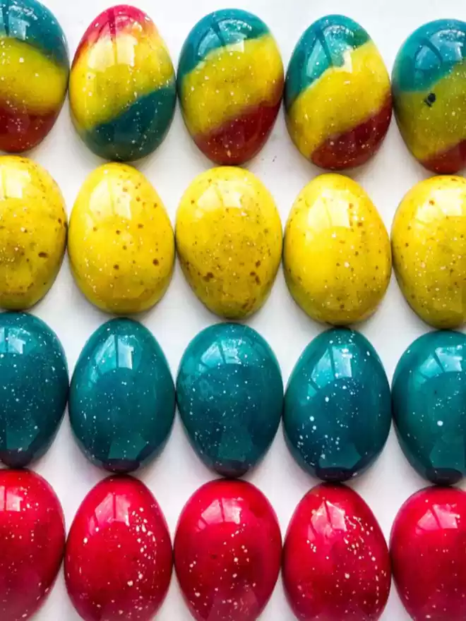 a row of colourful easter eggs on a marble surface