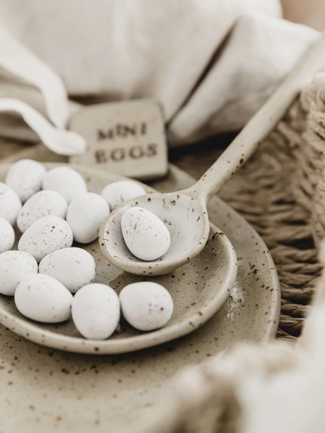 white ceramic spoon holding a white mini egg