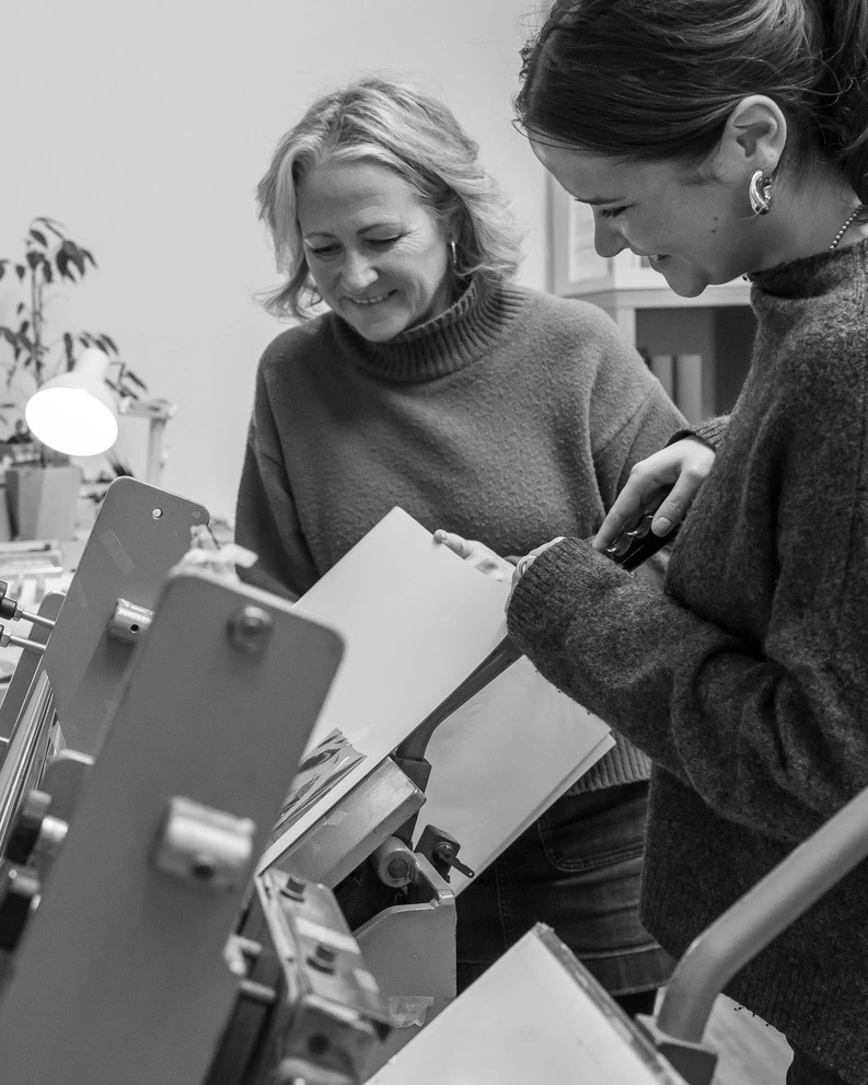 two people are together in a printing workshop about to print a photo album with personalised details on the front
