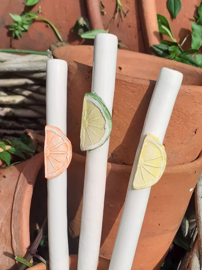 Lemon, Lime and Orange slice ceramic drinking straws in a stack of antique Victorian terracotta flowerpots