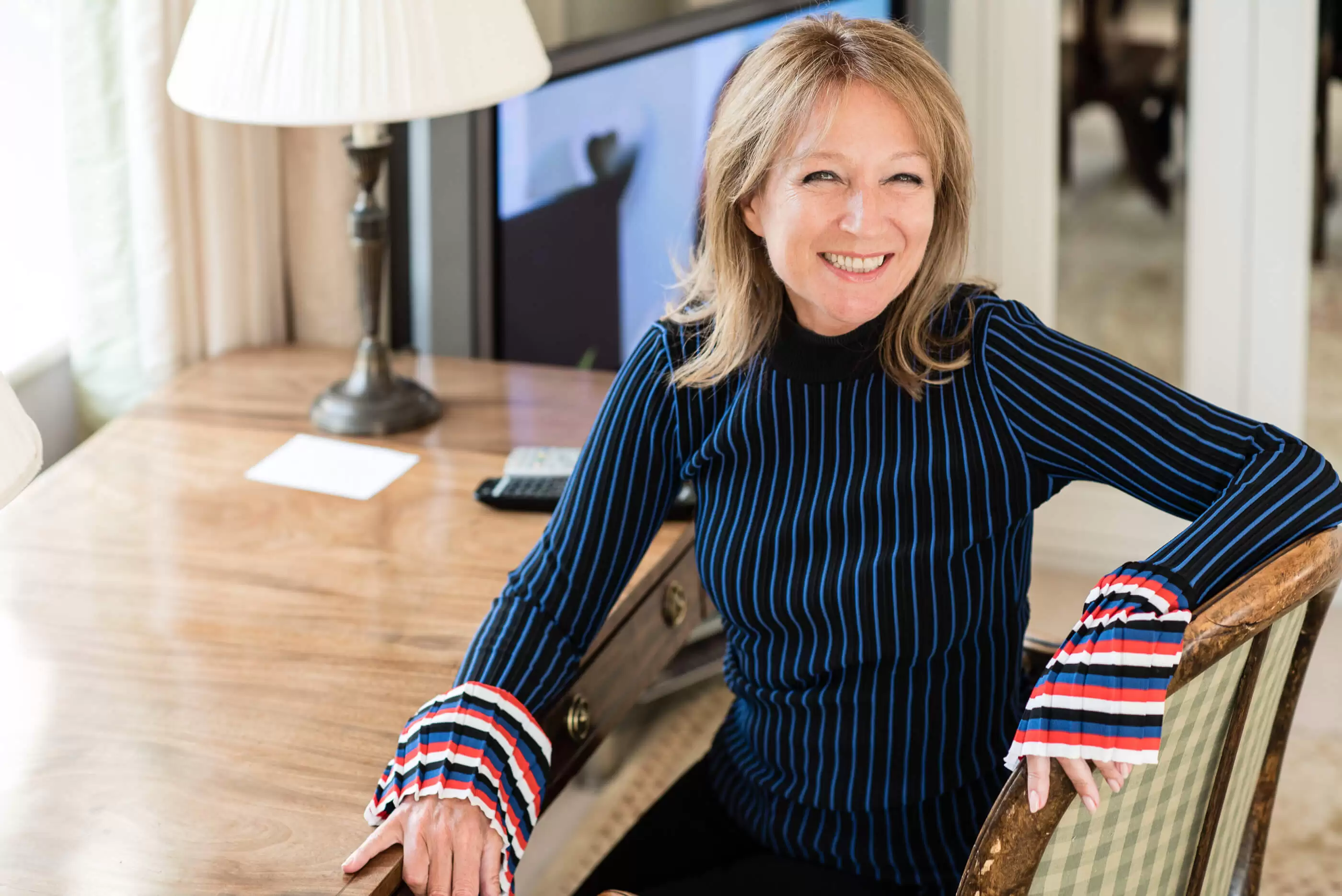 Rita Clifton CBE, co-founder of BrandCap, smiling at the camera in a blue and black striped top.