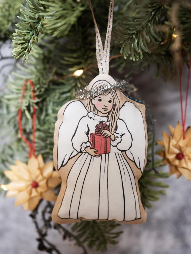 sweet angel illustrated Christmas tree decoration, angel is holding a present she has fair hair