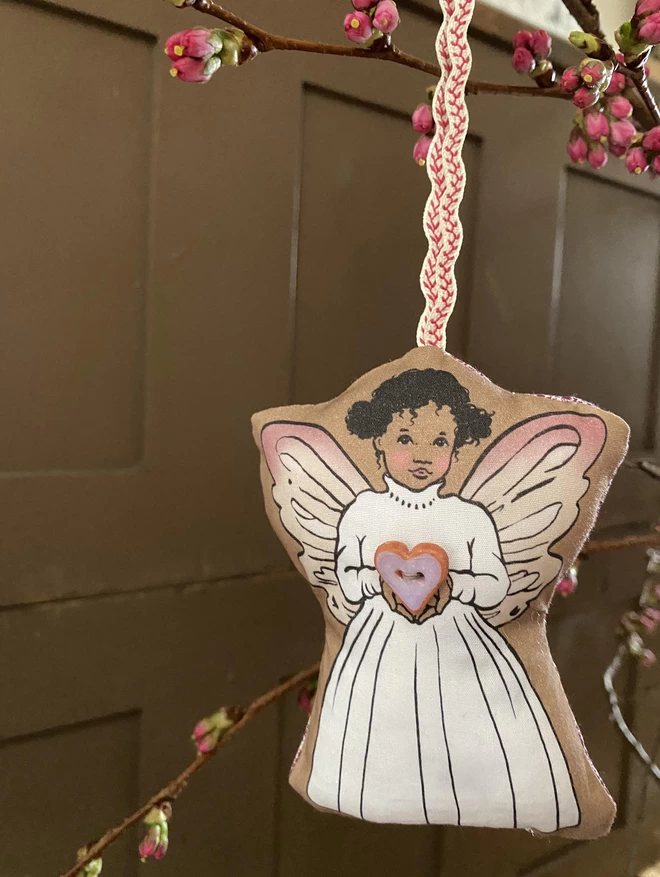 fairy plush hung ornament holding a pottery heart shaped violet button