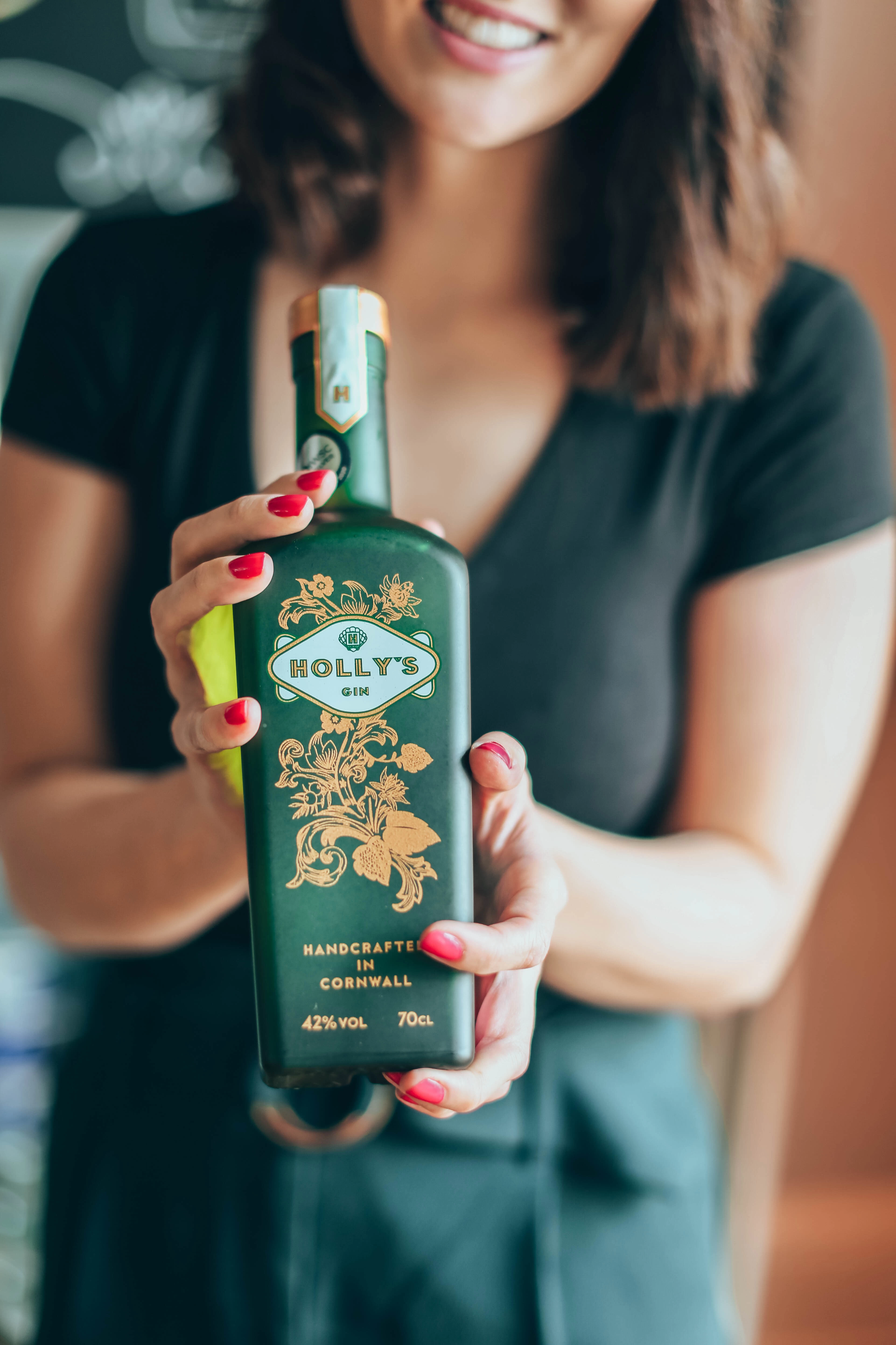 Holly holding a Holly's Gin bottle