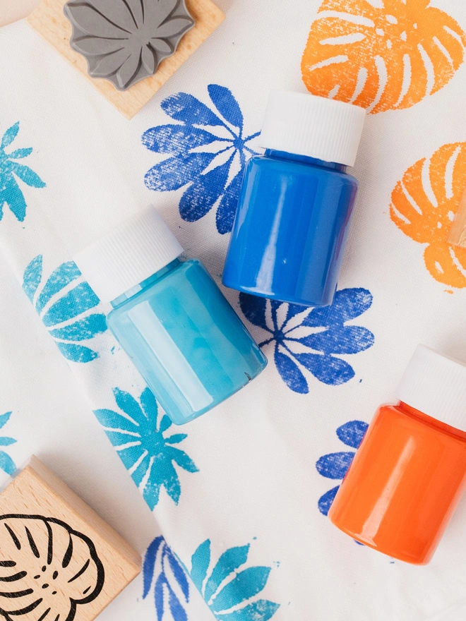 orange, blue and cyan paints on tea towel and stamps. part of diy kit by my papercut forest