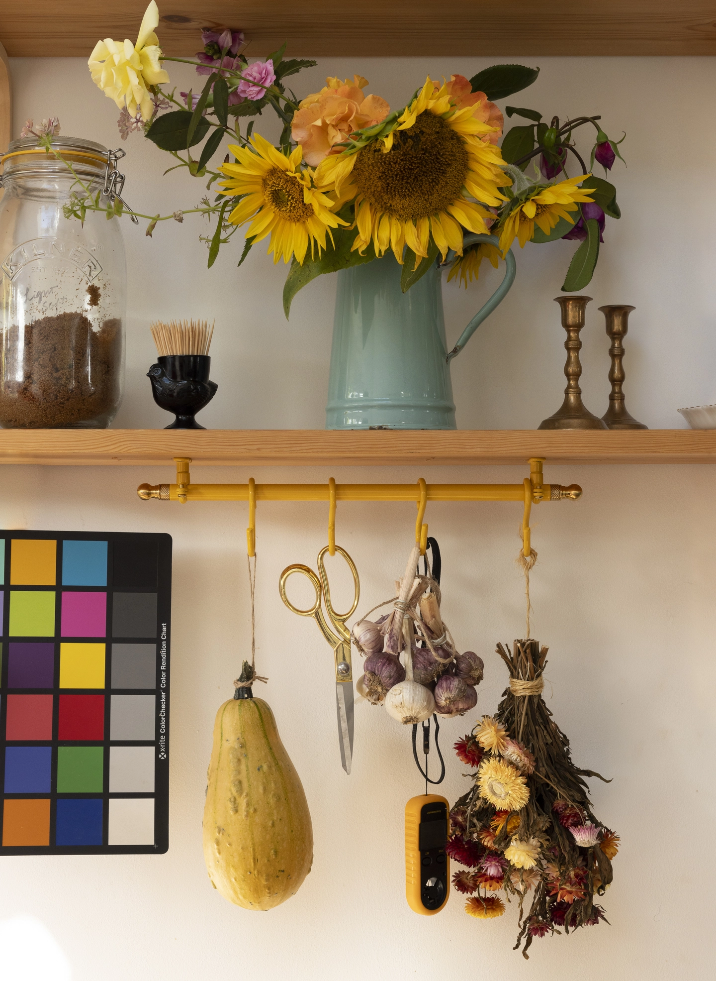 Yellow 40cm rail with dried flowers on hooks. Fitted under a shelf for layered storage.