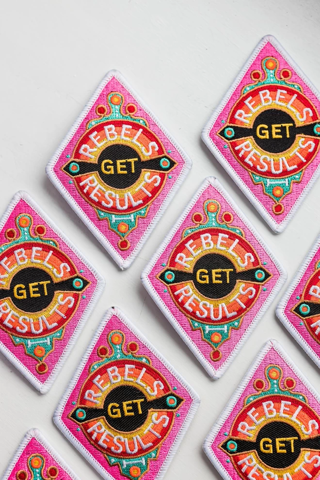 Iron-on patch that says 'rebels get results' designed by Rebecca Strickson