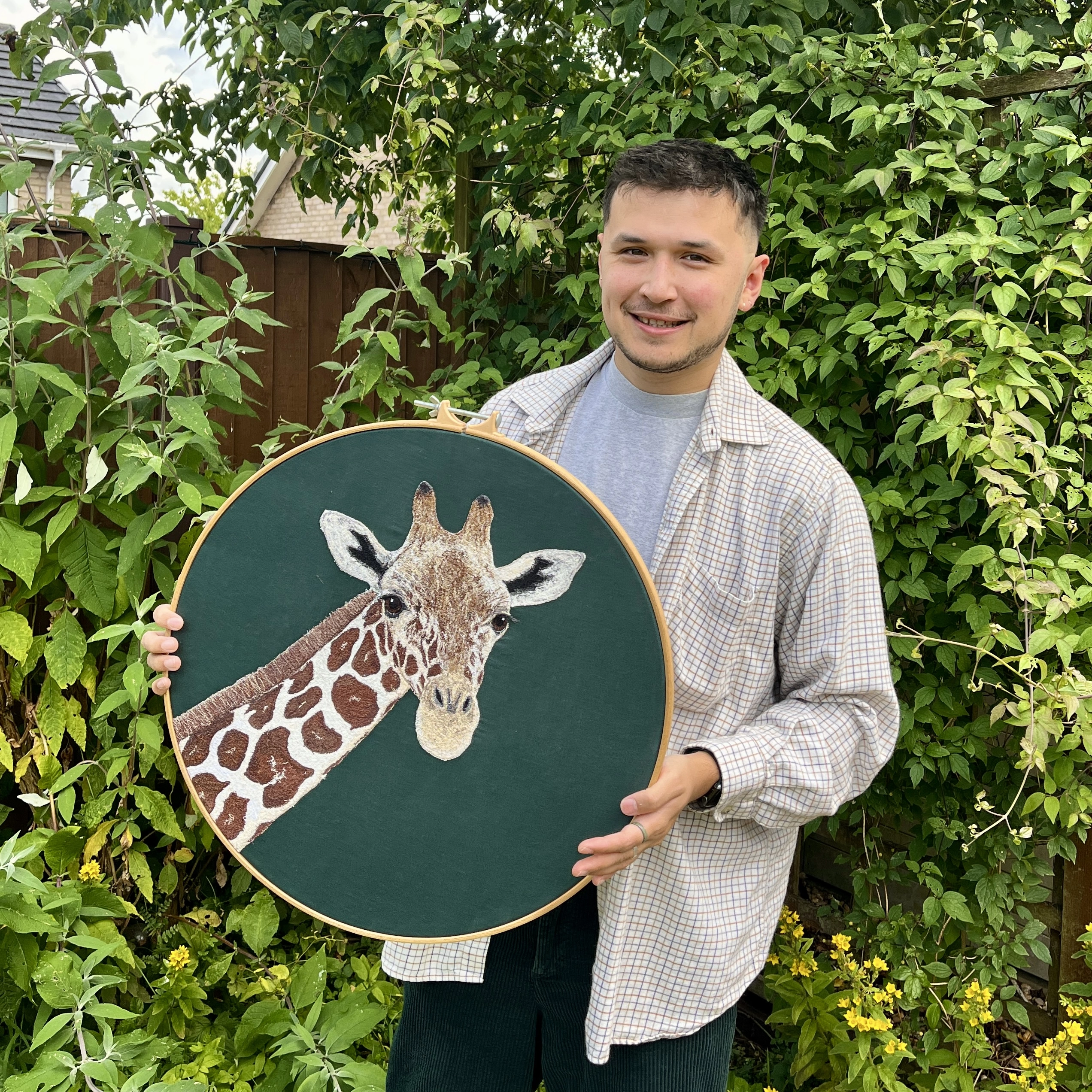 Alan from Stitched by Alan holding a Giraffe Embroidery