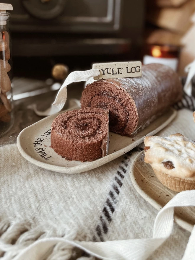 'Yule log' ceramic tag sat on top of a chocolate Yule log