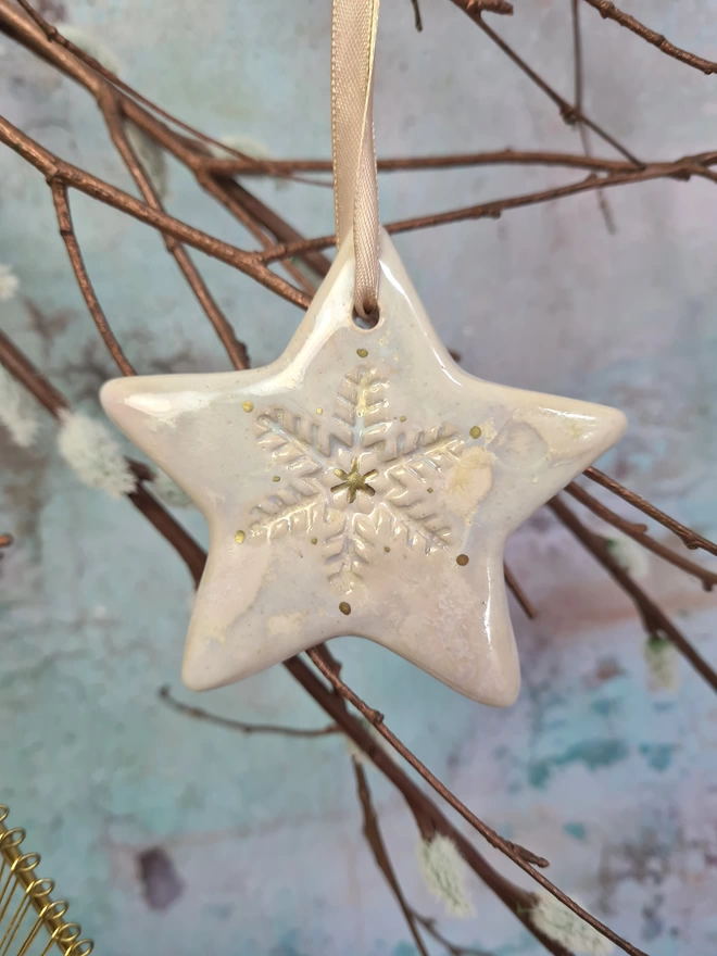 Star Christmas decorations, ceramic decorations, dream catcher, christmas star, pottery, Jenny Hopps Pottery, J.H Pottery, J.Hopps Pottery, Clay star, gift, christmas tree, pearlescent white and cream with gold details, on a light gold ribbon, photographed on a branch with Christmas lights