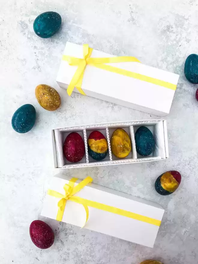 colourful easter eggs in a white box with a yellow ribbon