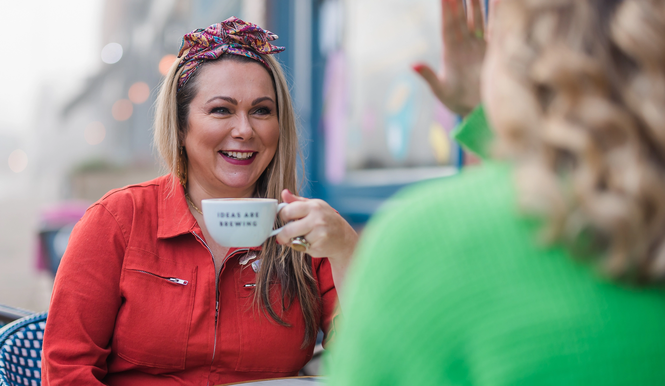 Holly Tucker MBE, founder of Holly & Co, enjoying a coffee in a mug that says 'ideas brewing'