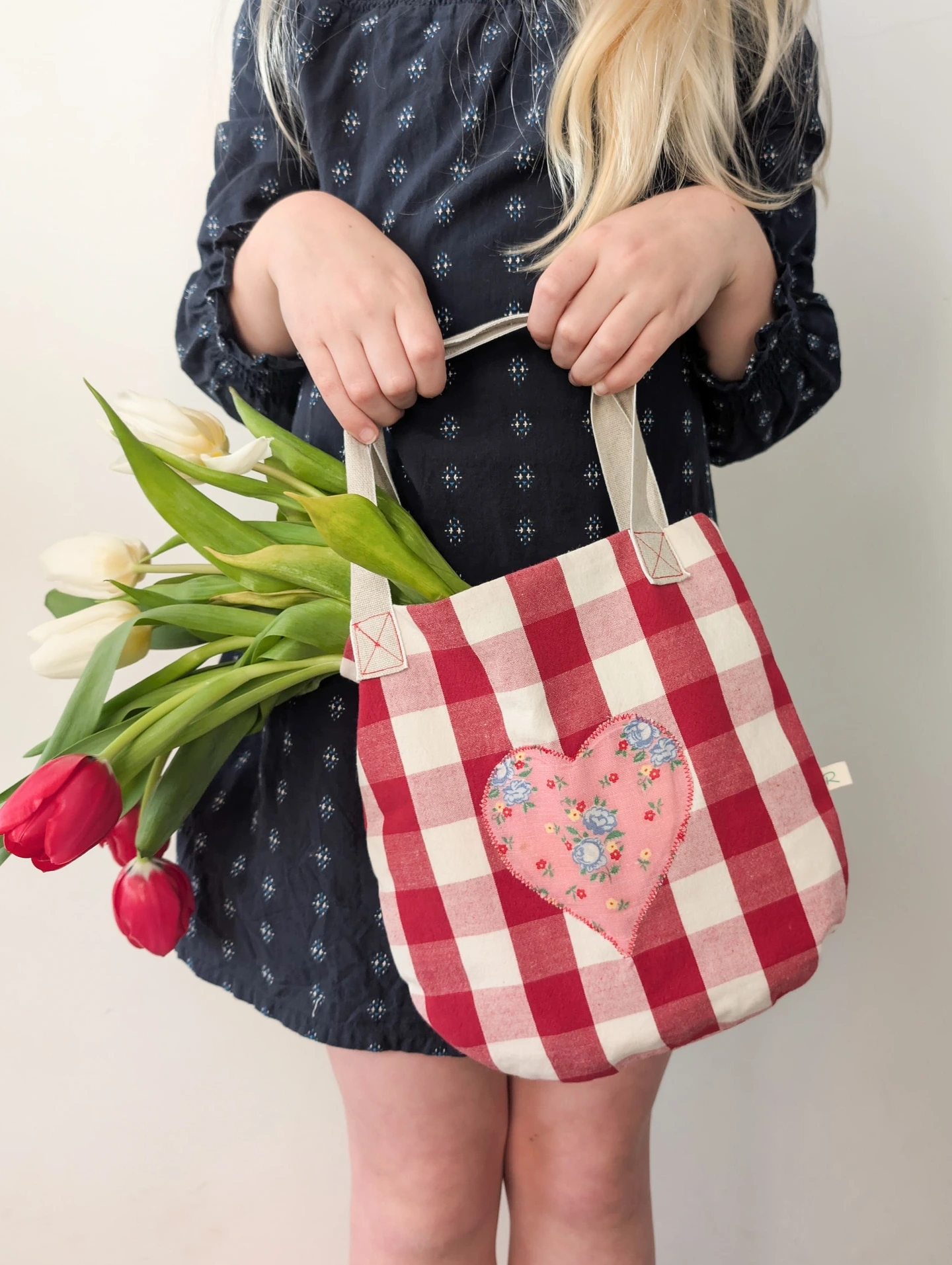 Little girl holding her Gingham Floral Heart Bag with Red Tulips