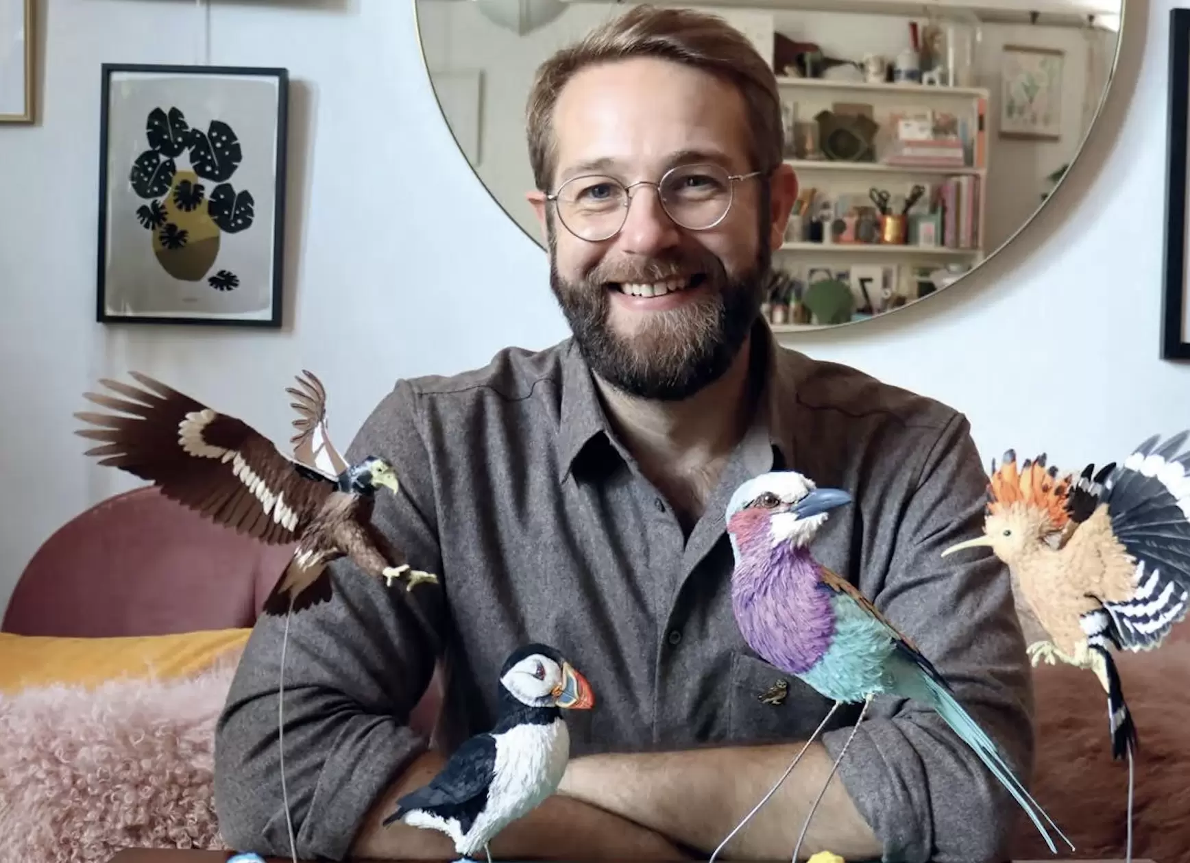 Zack McLaughlin, founder of Paper and Wood, sat with some of his paper bird sculptures