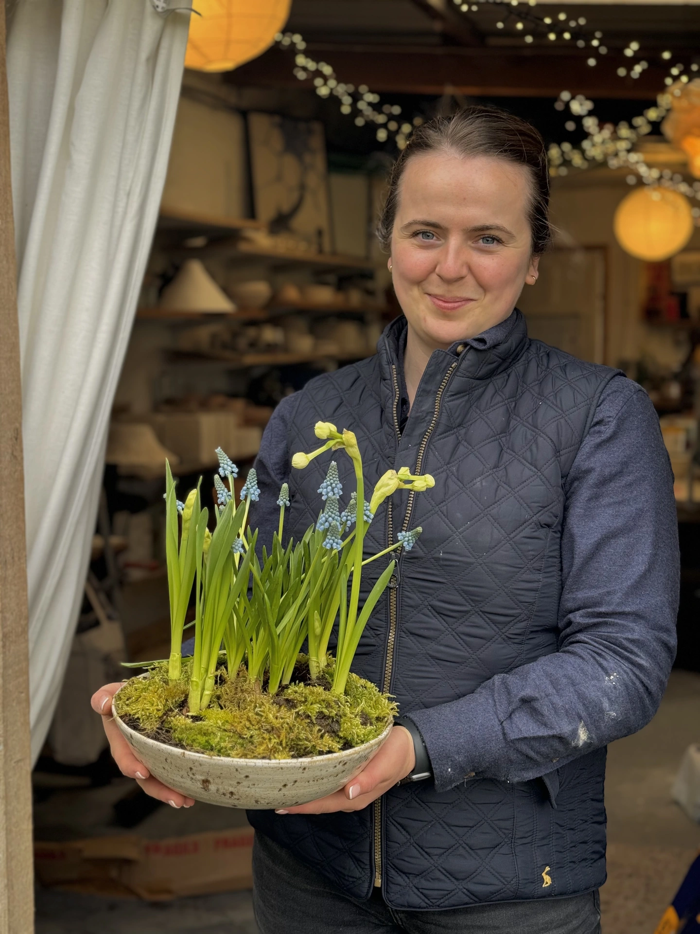 Myself holding a large planter bowl in the doorway of my studio