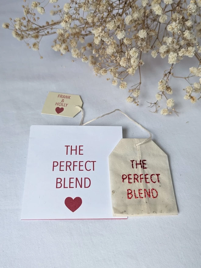 Embroidered The Perfect Blend teabag with paper sachet laid flat