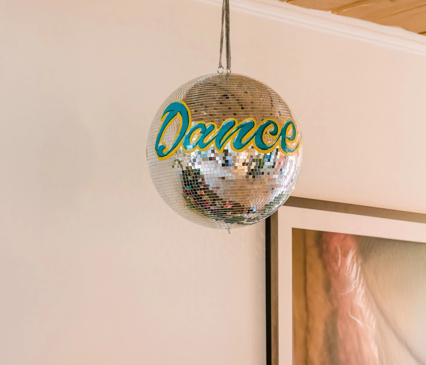 Hand sign painted disco ball with the phrase 'dance' on the front
