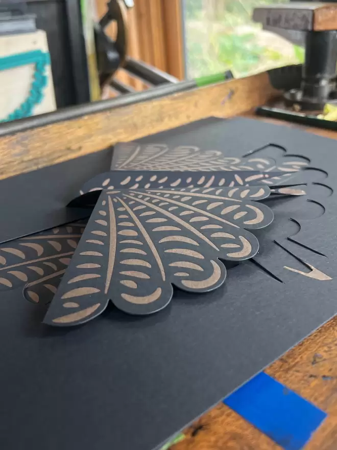 Die-cut letterpress printed bird shaped card on press.