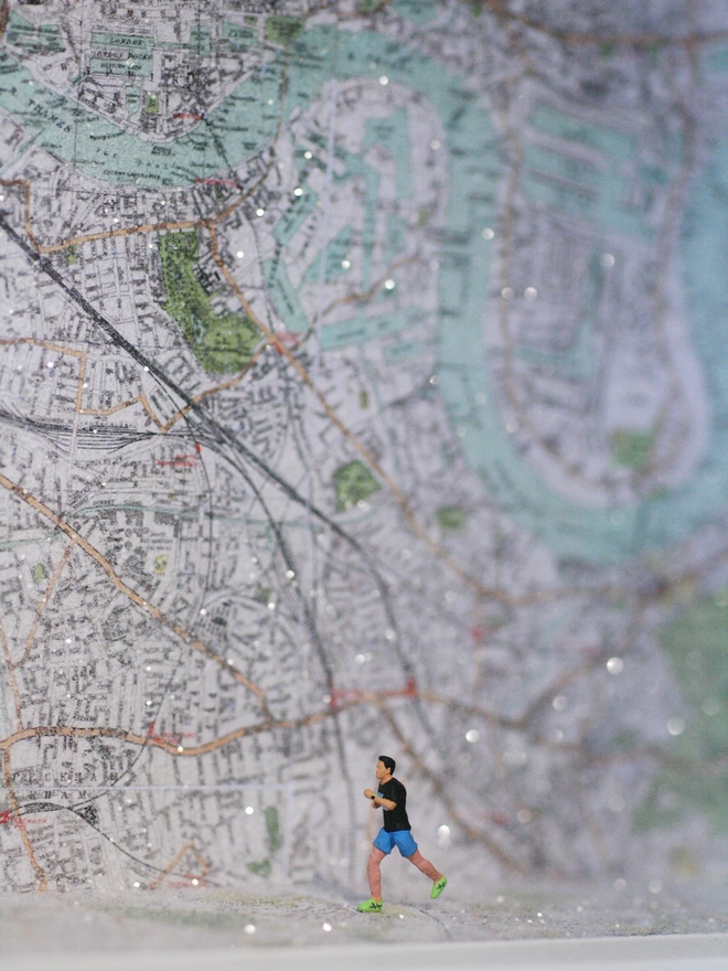 Artbox diorama showing a miniature runner against a backdrop of a map of London
