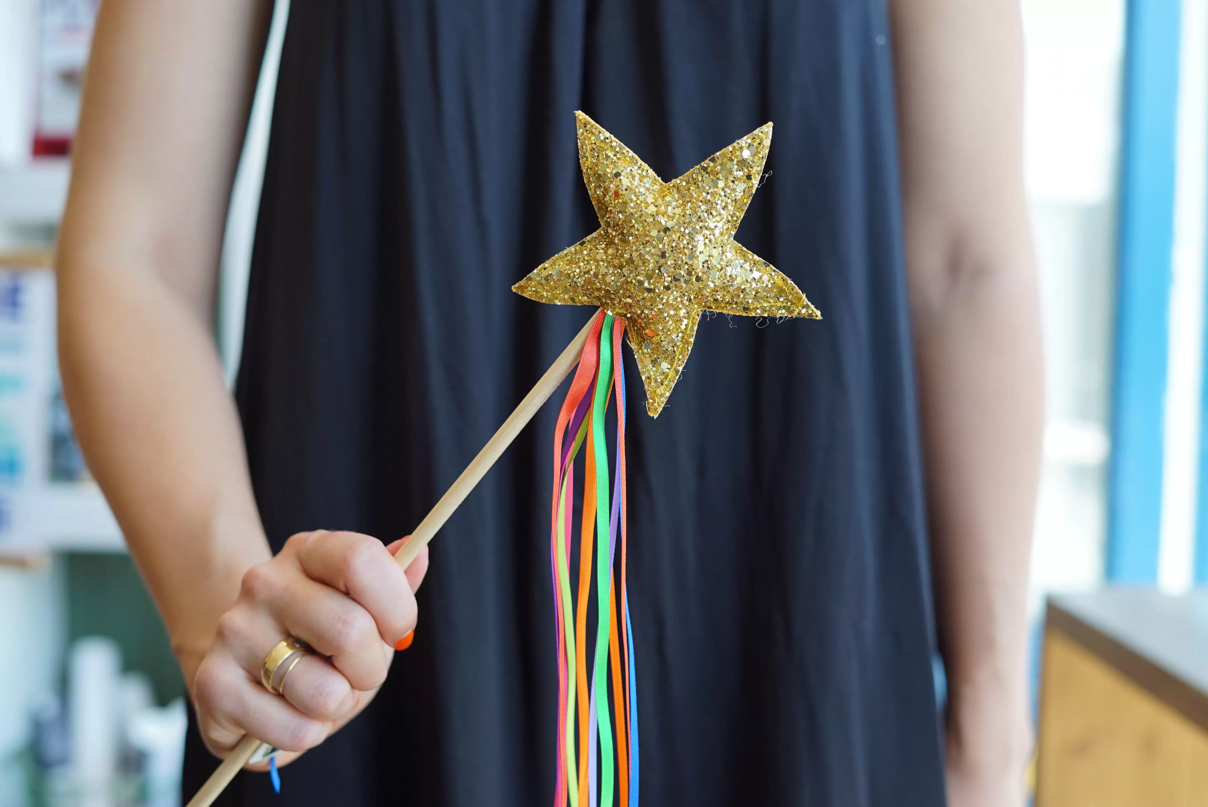 Woman wearing a blue dress holding a gold star wand