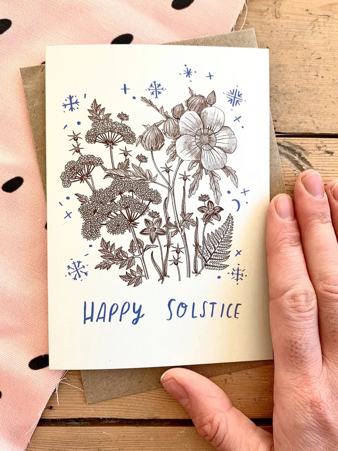 Cream background card reads 'Happy Solstice' with floral illustration