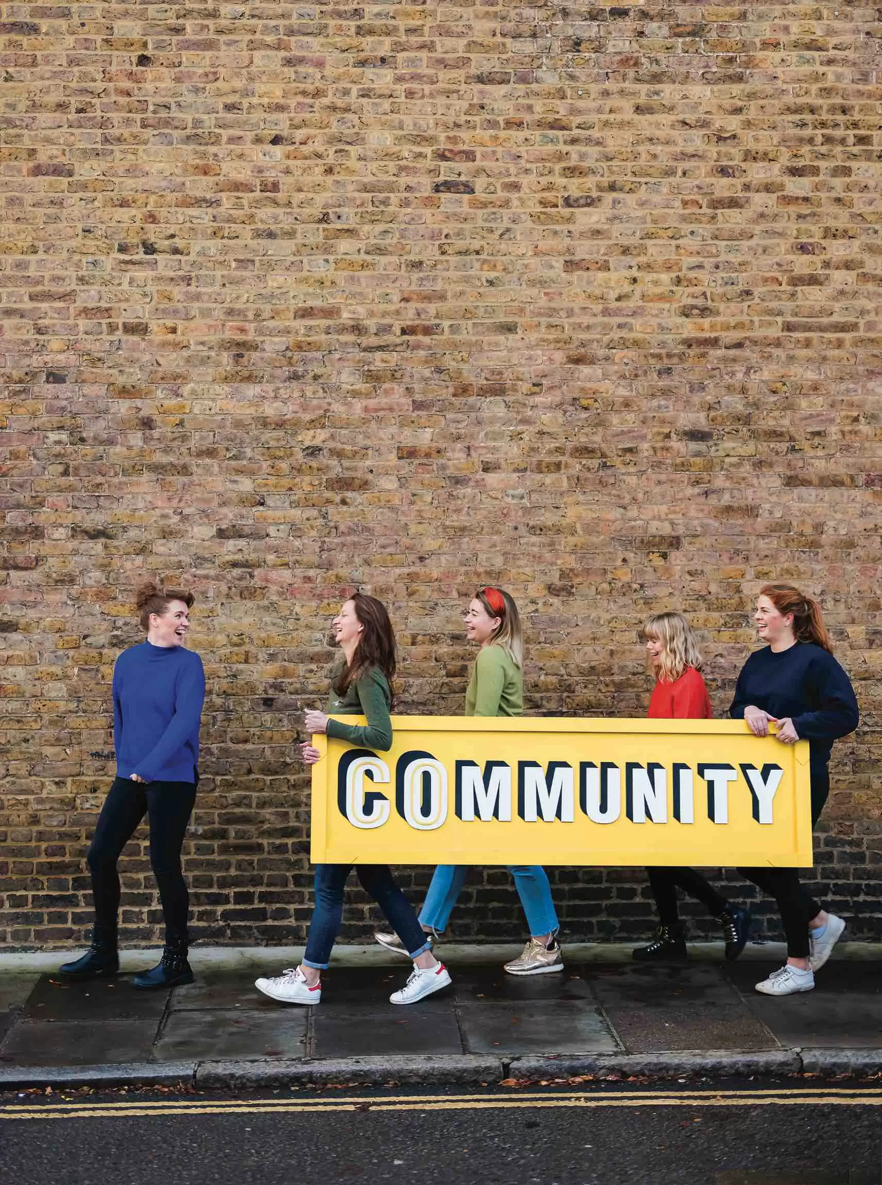 Group of women carrying a sign saying 'community'