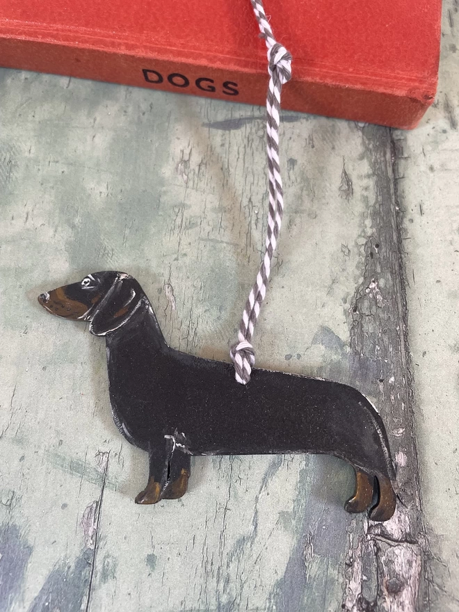 Black and Tan Dachshund Hand-painted Memorial Keepsake placed on a book about dogs