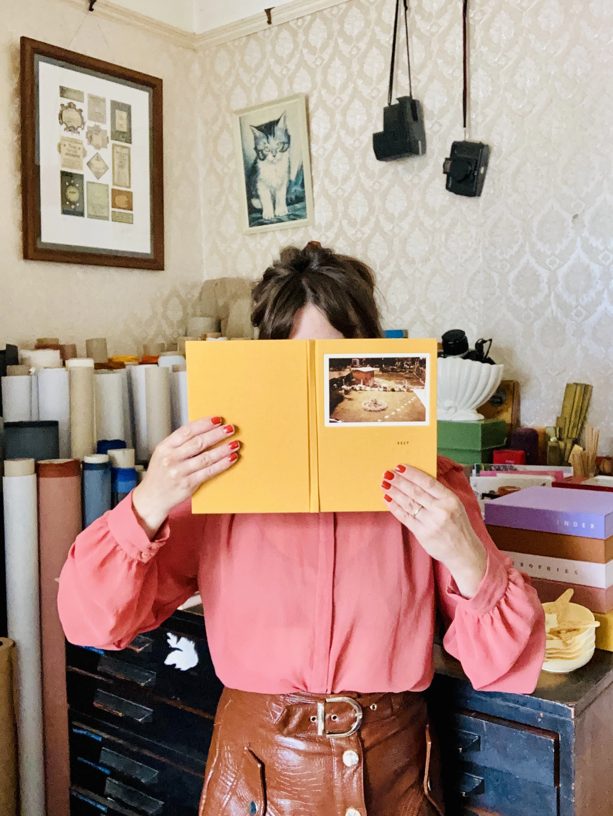 Keep Collect founder Cat in her Margate studio hiding behind one of her handmade books