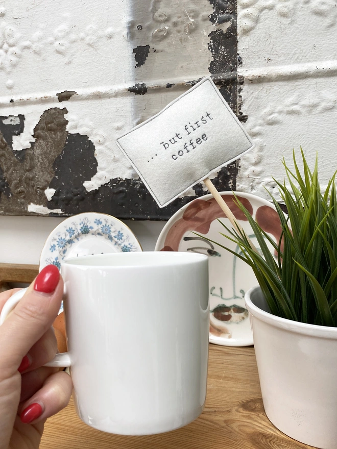 but first coffee embroidered sign in plant with mug