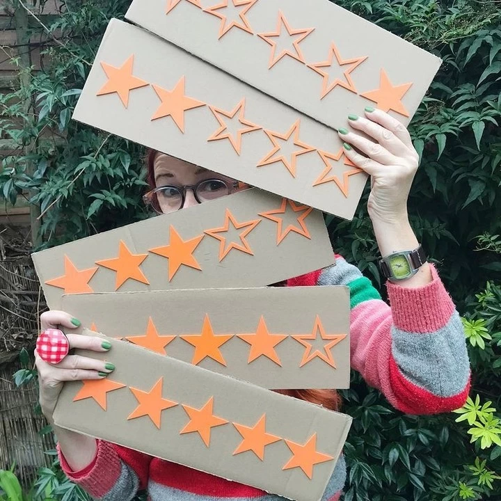 Woman from Twisted Twee holding review placards