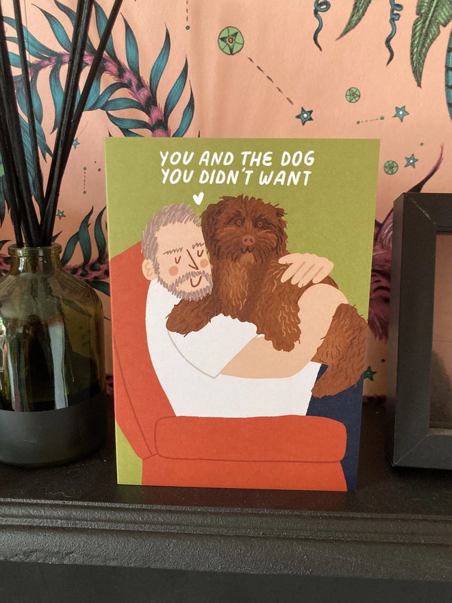 Dad hugging dog card, placed on a fireplace mantle