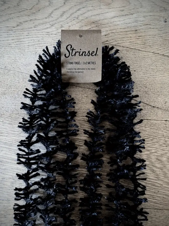 Multipack of Spider Leg Strinsel with label AKA Jute string tinsel on an oak table