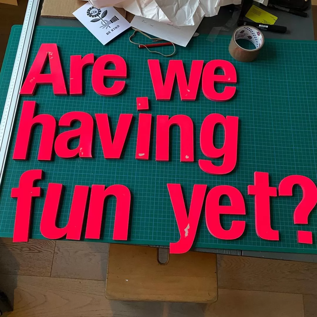 Are we having fun yet sign with red letters on a green background