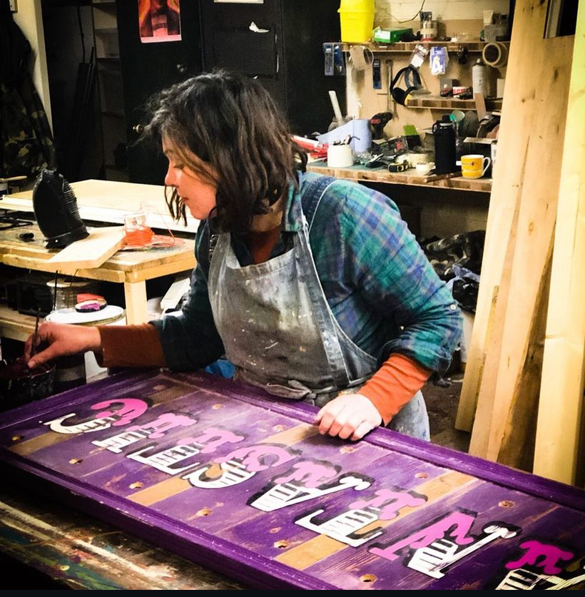 Danielle of Argent and Sable painting a sign