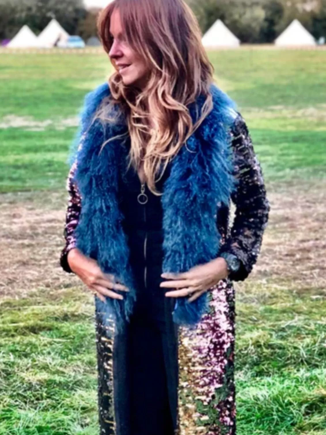 Found of Rock The Jumpsuit Rachel wearings a blue fur collared sparkling long coat in a field