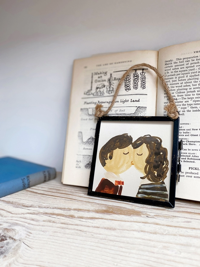 framed portrait of two people kissing