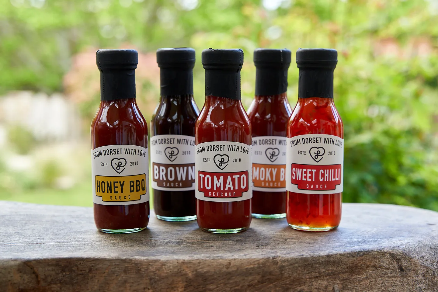 Ketchup sauces bundle on a wooden board outside