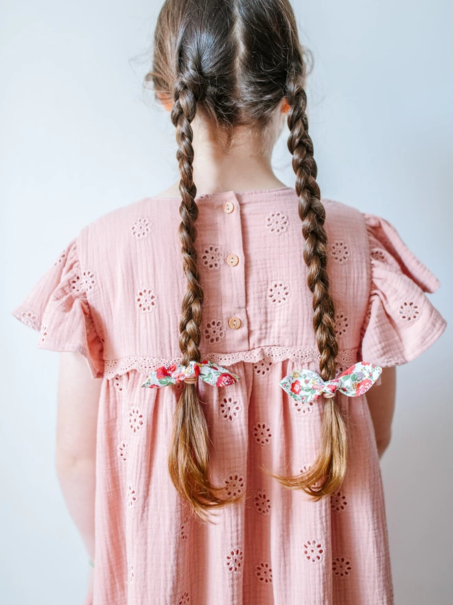 girl with long plaits and hair bobbles in Liberty fabric