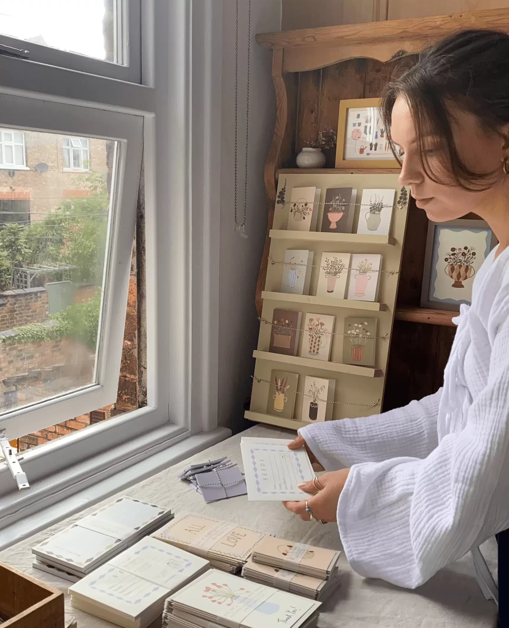 Harriet Watson in her studio sorting through her floral cards and products.