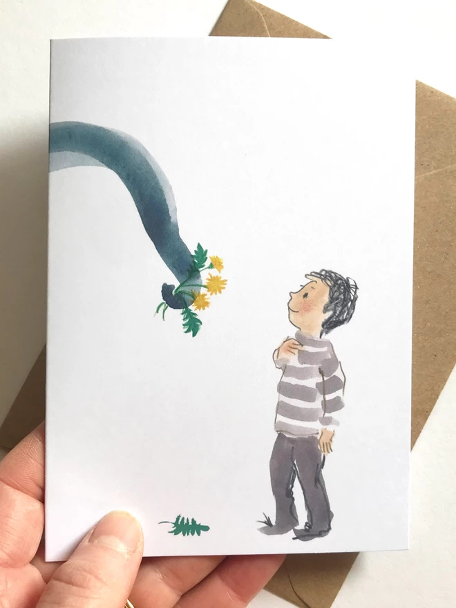 White illustrated card by Esther Kent, shows a small person in a striped top receiving a guft of flowers held in an elephant's trunk.