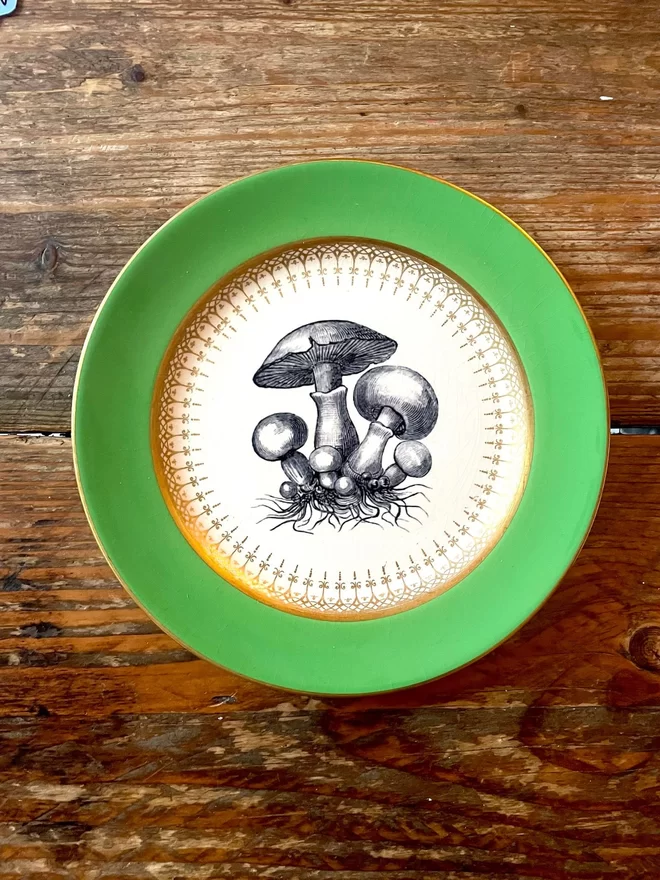 vintage plate with an ornate border, with a printed vintage illustration of mushrooms in the middle