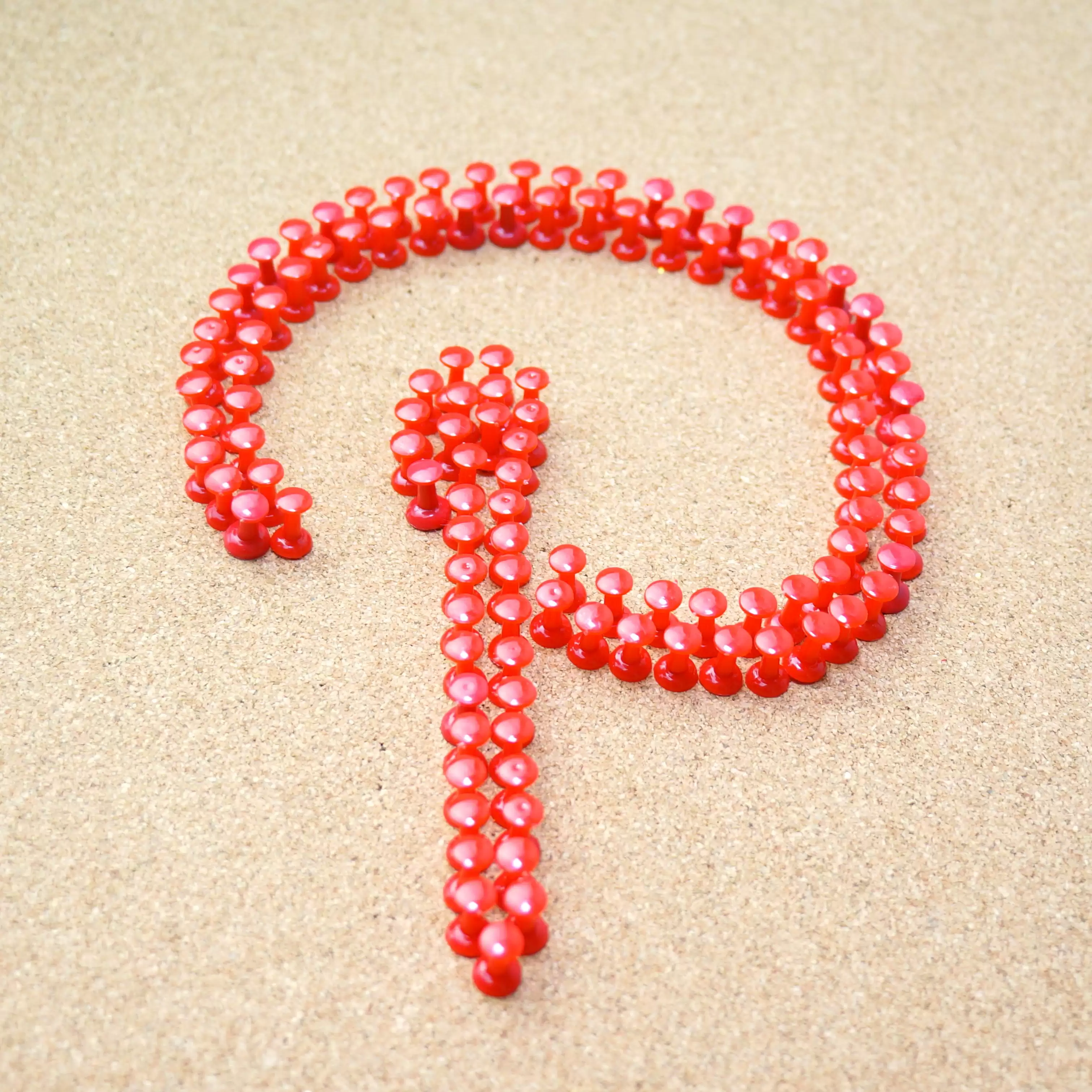 Pinterest Logo made of red pins on a neutral coloured background