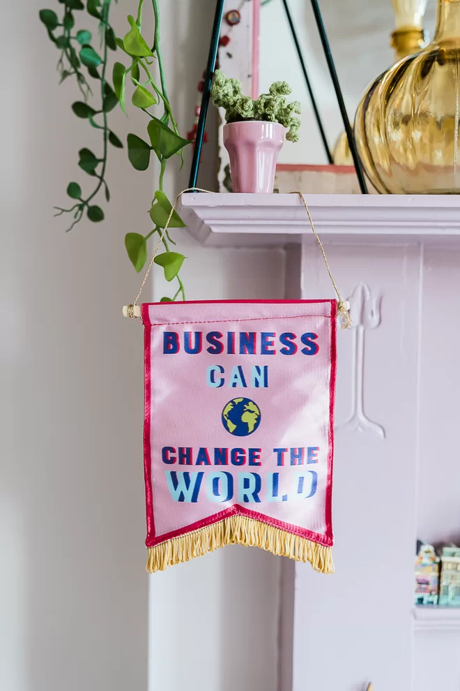 Business Can Change The World Pink Banner Hanging off Fireplace 